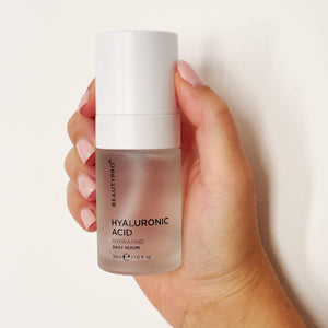 Hand holding BEAUTYPRO Hyaluronic Acid serum pump bottle — daily hydrating face serum for plump supple skin