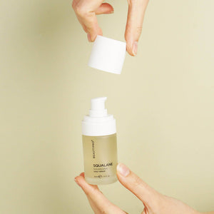 Hand holding BEAUTYPRO Squalane Nourishing Serum pump bottle — daily hydrating serum for dewy glowing skin